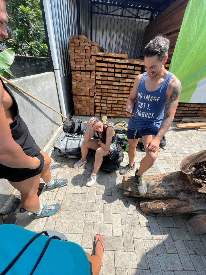 ruta por indonesia riéndose un chico y otra chica sentada en una mochila angustiada